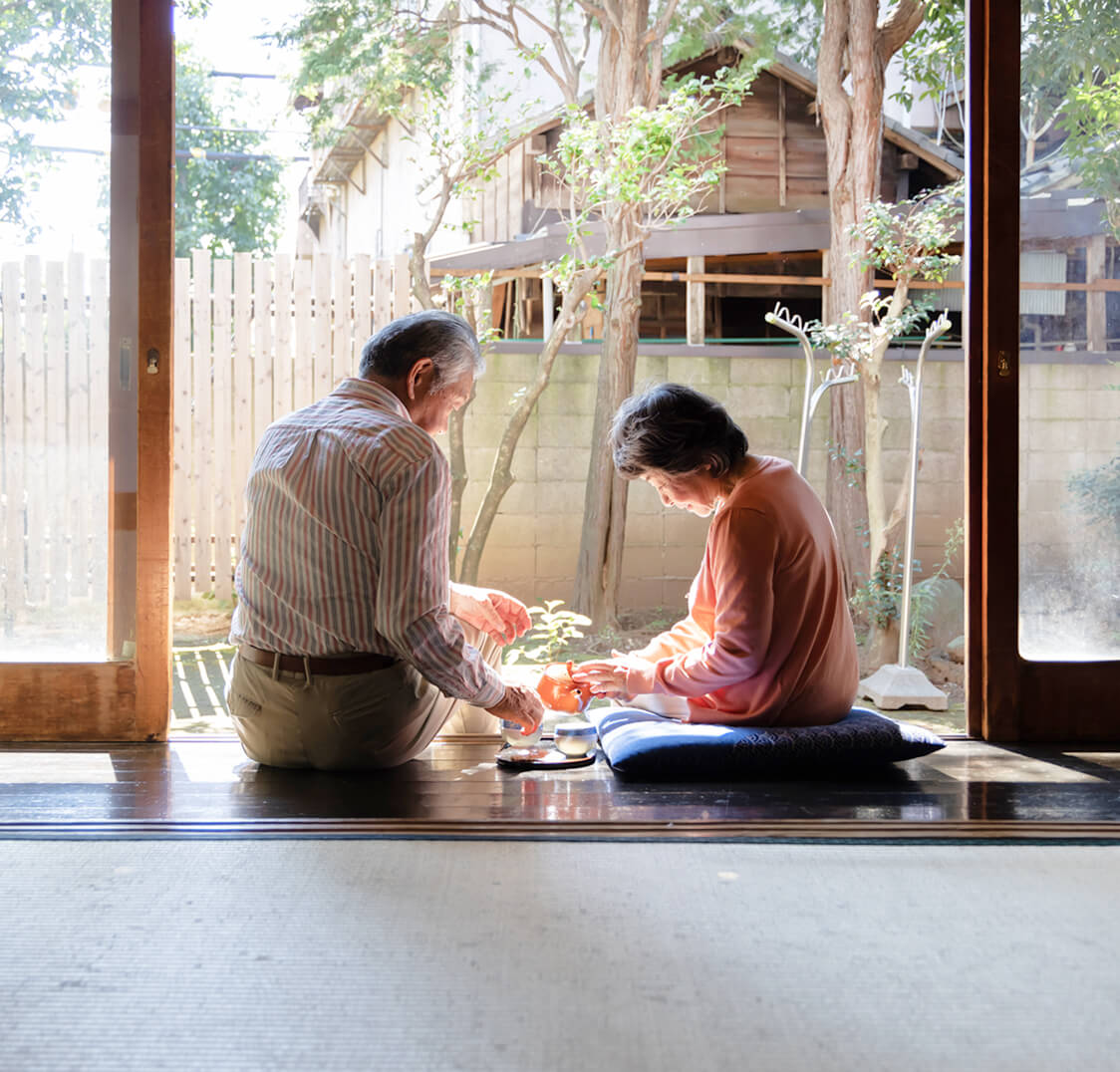 縁側で笑いあう夫婦